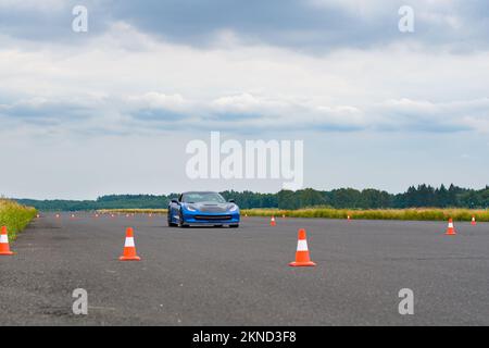 Modern car at test track, focus on traffic cone. Driving school Stock Photo