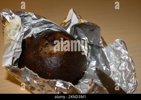 Traditional finnish rye flour bread (Kalakukko), stuffed with vendace, freshly heated and unwrapped from aluminium foil Stock Photo