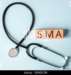 SMA, spinal muscular atrophy, Written on wooden blocks, a rare disease in which, due to a genetic defect, neurons in the spinal cord responsible for m Stock Photo