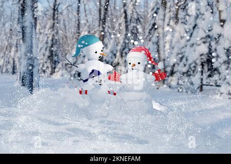 Snowman family in the snow. Christmas card. Stock Photo