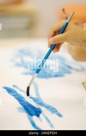 Children painting in kindergarden. Hand of little girl hold brush and paint Stock Photo