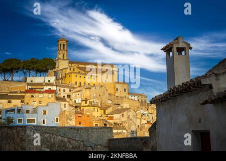 View of the colorful and historic old town of Cehegn with the Magdalena church in the background on a hill and a traditional house with a chimney in t Stock Photo