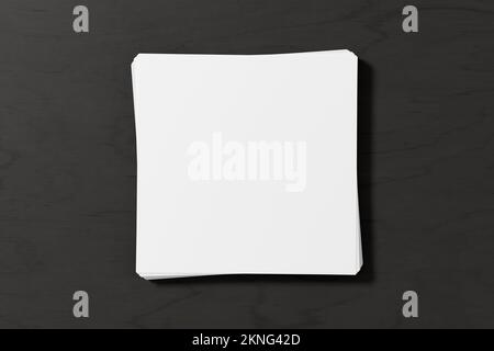 Stack of square sheets of paper on the dark wooden table Stock Photo