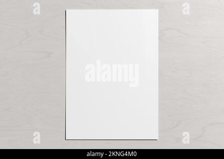 Blank sheet of paper mock up on the white wooden table Stock Photo