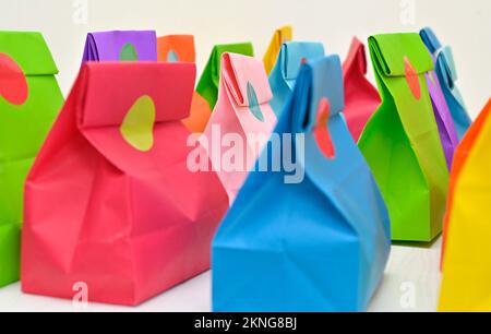 Set of colorful shopping folded paper bags on white background. Paper shopping bags mockup, blank rectangular gift packs. Mock up for brand and logo. Stock Photo