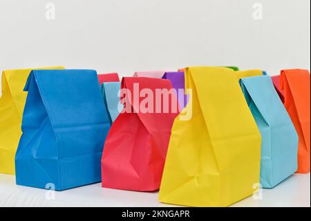 Set of colorful shopping folded paper bags on white background. Paper shopping bags mockup, blank rectangular gift packs. Mock up for brand and logo. Stock Photo