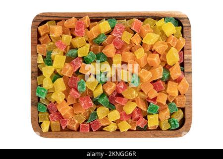heap of candied fruit pieces close up isolated on white background, sweet dried pineapples, oranges and papayas in sugar syrup in wooden tray, used in Stock Photo