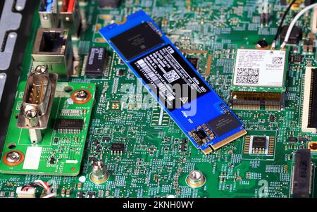 The blue SSD PCle NVMe M.2 on green motherboard background Stock Photo