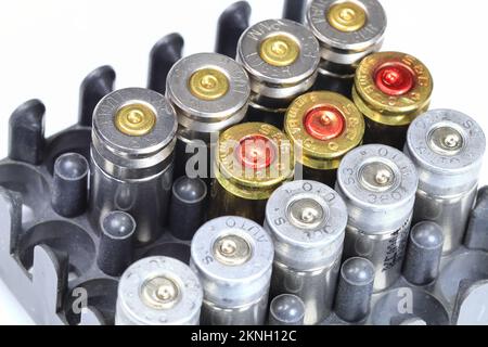 Vareity of used ammunition shells in a plastic box isolated on white background Stock Photo