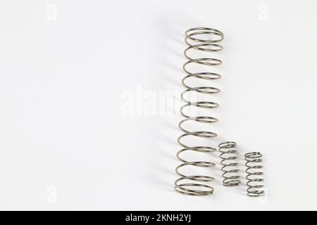 Various metal springs for different purposes, many small chrome springs, Metal spring isolated on white background. Stock Photo