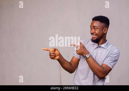 An Afro American man amazed, while presenting with hand and pointing with fingers Stock Photo