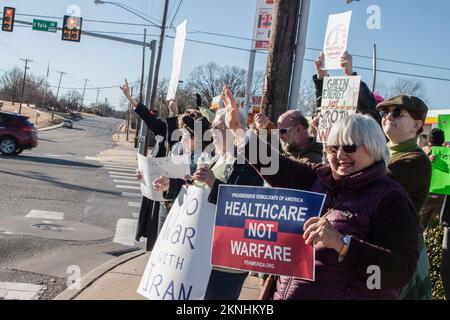 01-04-2020 Tulsa USA Peaceful anti-war protestors with smiles and signs waving at passersby on street corner. Stock Photo