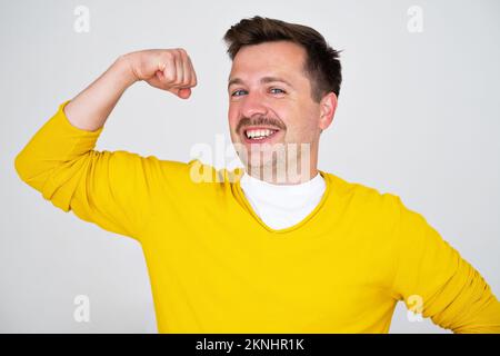 Young caucasian man showing arms muscles smiling proud Stock Photo