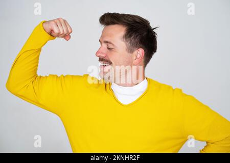 Young caucasian man showing arms muscles smiling proud Stock Photo