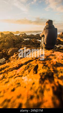 Travel and lifestyle portrait on the back of a man marvelling at the wonderful scenes at Western Tasmania's Granville Harbour, Australia Stock Photo