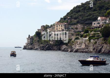 Boaters along the scenic and rocky stretch of the Amalfi Coast in the village of Marmorata, a hamlet of Ravello, in Campania, in Southern Italy. Stock Photo