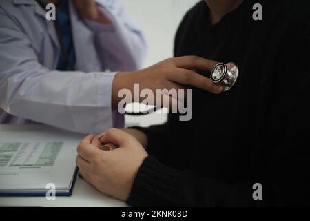 Doctor use stethoscope checking up heart beat of the patient. Stock Photo