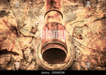 Nautical and maritime artwork of rusty and vintage spyglass on stained paper map backdrop Stock Photo