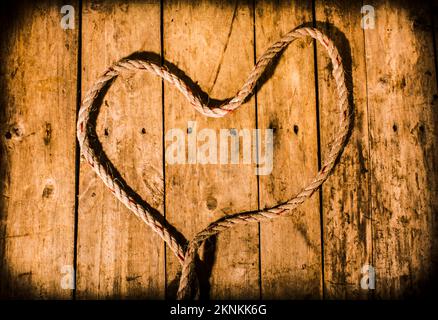 Wooden marine decor in the form of a ship shape heart on planked boating deck Stock Photo