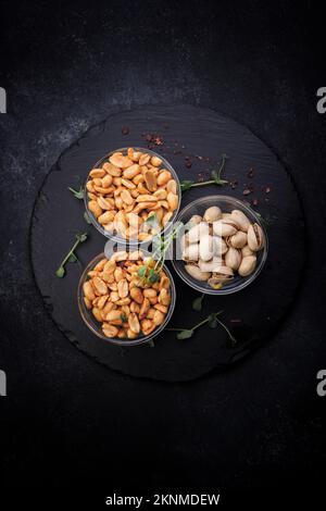 Salted nuts, pistachios and peanuts, for beer, on a dark background Stock Photo
