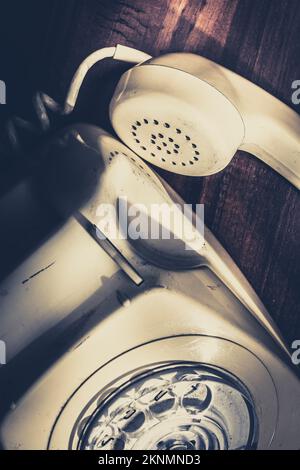 Closeup old still-life photo of a landline telephone detached from an unanswered communication of urgency. Call of the unheard Stock Photo