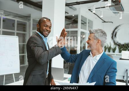Two multiethnic business colleagues working together in modern office Stock Photo