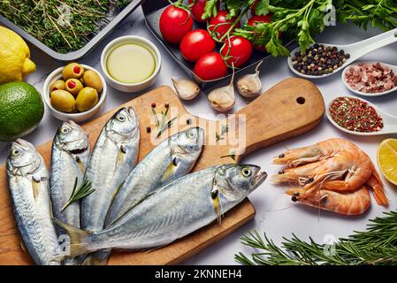 Fresh Fish Food background. Different seafood, shrimps and red caviar. Fish for cooking with herbs, vegetables and spices isolated on white background Stock Photo