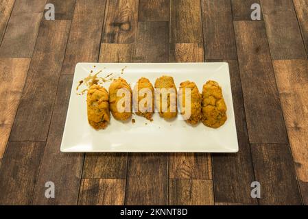 A wonderful tapa of homemade croquettes stuffed with mushrooms on a white porcelain tray Stock Photo