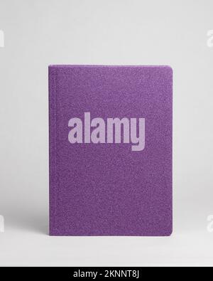 Purple diary in standing view on table on white background. Frontside Stock Photo