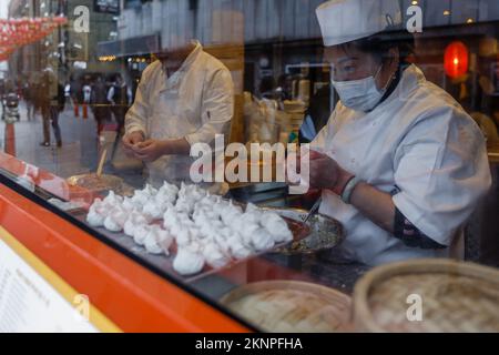 A view through the window of cooks preparing dumplings at the Beijing Dumpling restaurant in London's Chinatown. Stock Photo