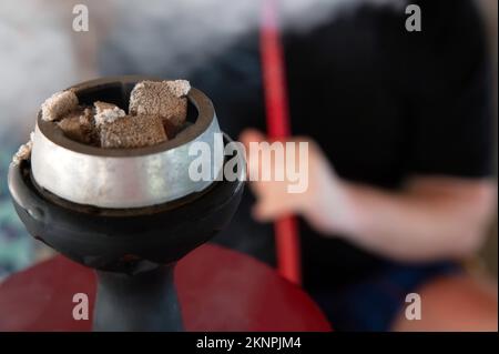 Shisha hookah with red hot coals and smoker on background Stock Photo