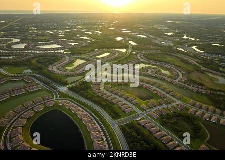 Aerial view of tightly located family houses with retention ponds to prevent flooding in Florida closed suburban area. Real estate development in Stock Photo