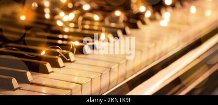 Piano keys with glowing Christmas lights, closeup Stock Photo