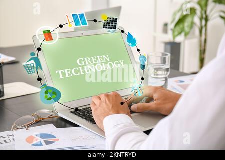 Businessman using laptop in office. Green technology concept Stock Photo