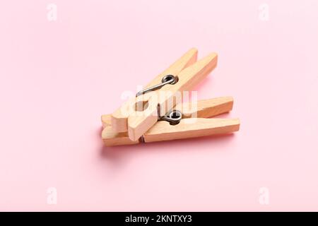 Two wooden clothespins on pink background Stock Photo