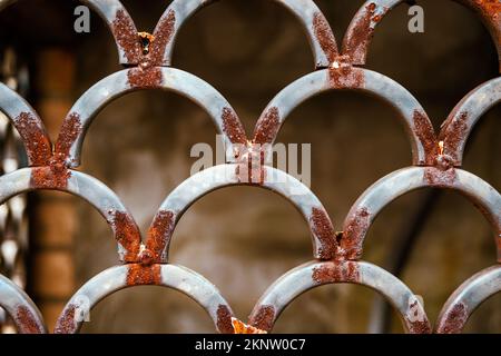 Worn and rusted old metal grate under stairs. Stock Photo