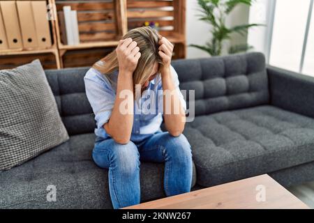 Young blonde woman patient having psychology session at clinic Stock Photo
