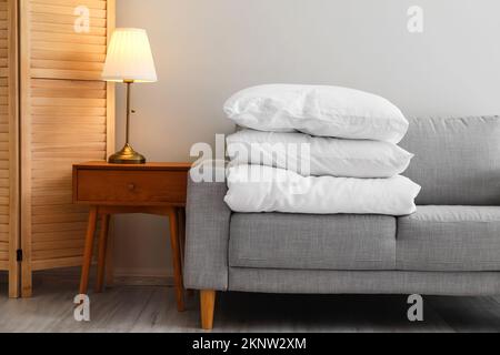 Stack of blanket and pillows on comfortable sofa Stock Photo