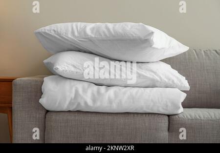 Stack of blanket and pillows on comfortable sofa Stock Photo