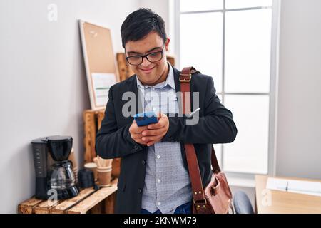 Down syndrome man business worker using smartphone at office Stock Photo