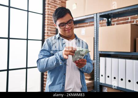 Down syndrome man ecommerce business worker counting dollars at office Stock Photo