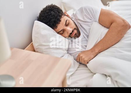 Young arab man lying on bed sleeping at bedroom Stock Photo