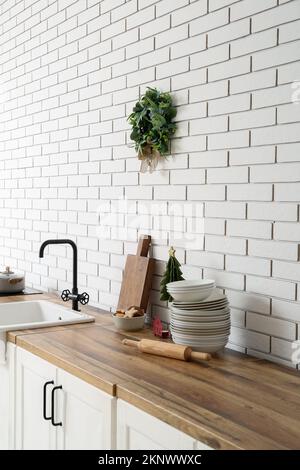 Christmas mistletoe wreath hanging on white brick wall in kitchen Stock Photo