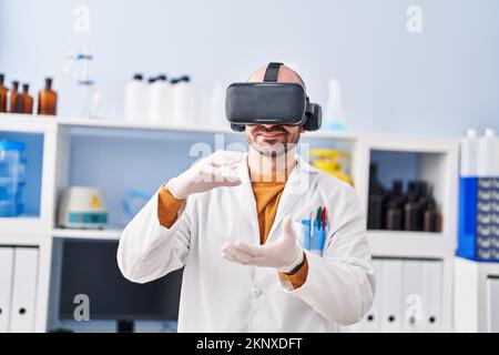 Young man scientist using virtual reality goggles at laboratory Stock Photo
