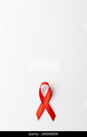 Vertical composition of red ribbon for hiv or aids awareness, on white background with copy space Stock Photo