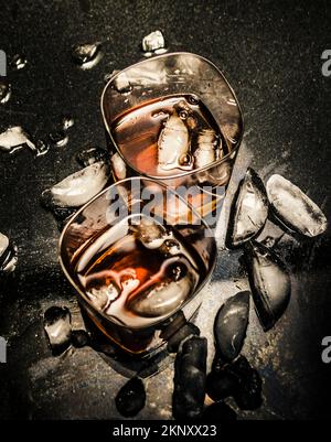 Scotch on the rocks for two in a contrasted bar scene of a smashing party. Ice Breaker Stock Photo