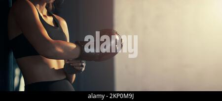 Close-up young woman wearing boxing glove in the gym. Stock Photo