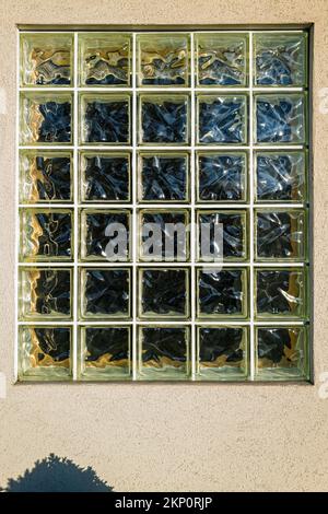 Wavy glass block windows are installed on an exterior wall of a building Stock Photo