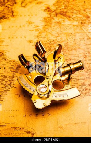 Vintage nautical adventure in a still life scene of brass sextants and old world maps. A Plot In Navigation Stock Photo