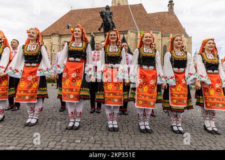 Romanian and Hungarian folk dancers in front of Church of Saint Michael at Unirii Square, Cluj-Napoca, Romania Stock Photo
